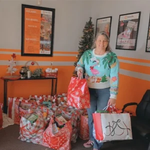 A Benevilla volunteer holds holiday gift bags prepared for the Santa for a Senior program, helping bring joy to homebound seniors